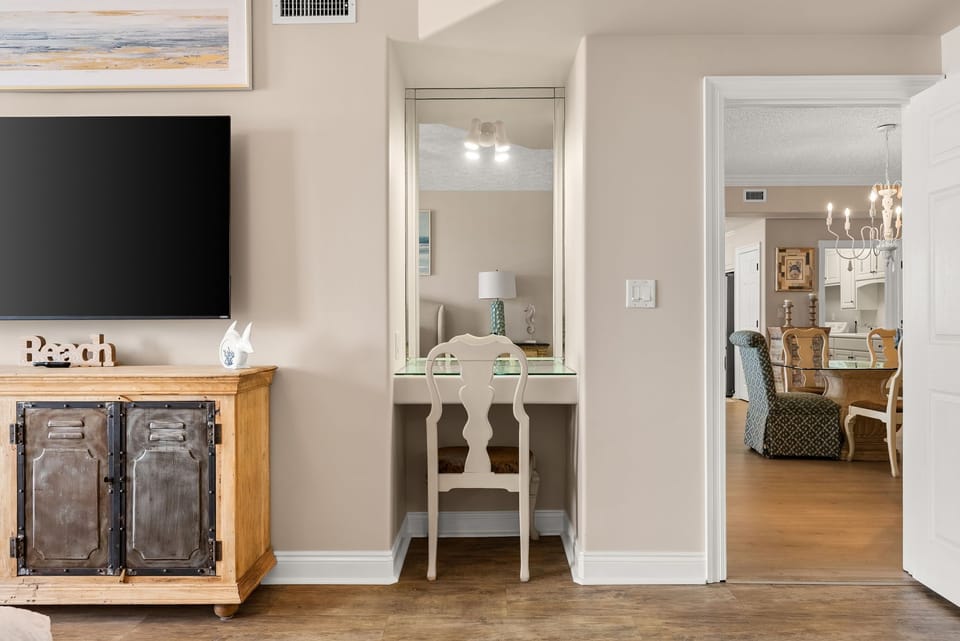 A cozy corner with a vintage-style vanity and a view into the dining area.