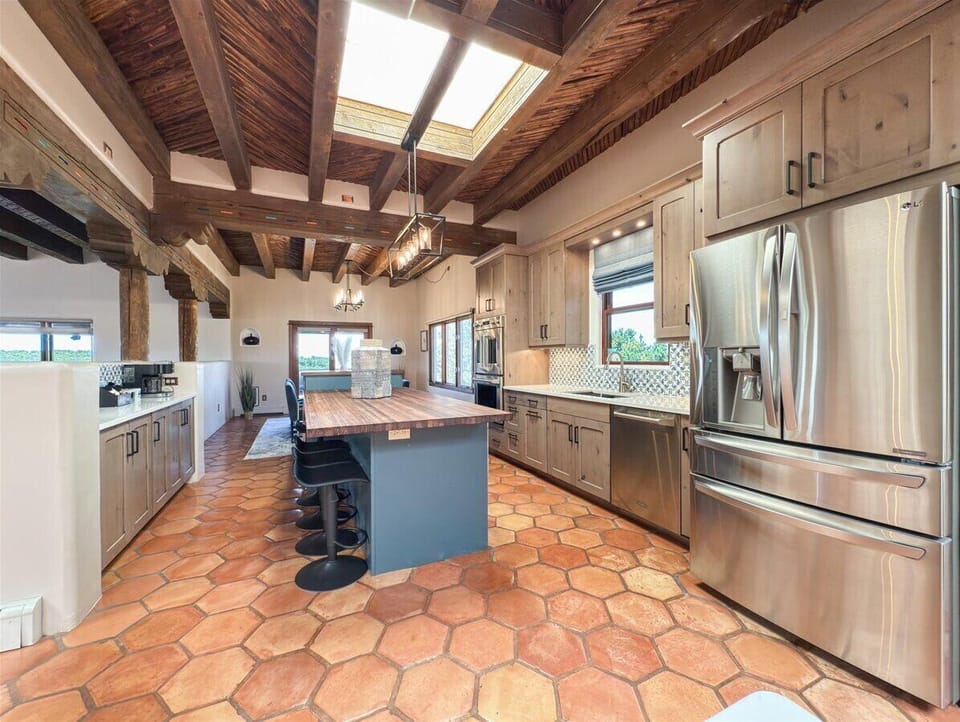 Spacious Kitchen with Island Seating and Soaring Beamed Ceilings

