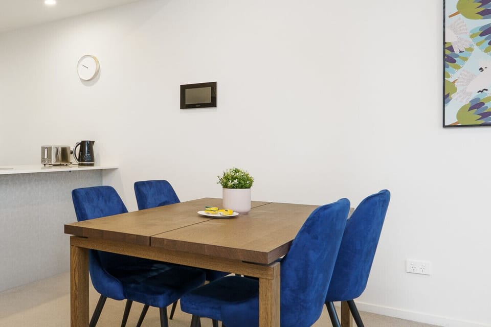 Inviting four-seat dining table with plush blue chairs—ideal for breakfast, coffee, and easy meals.