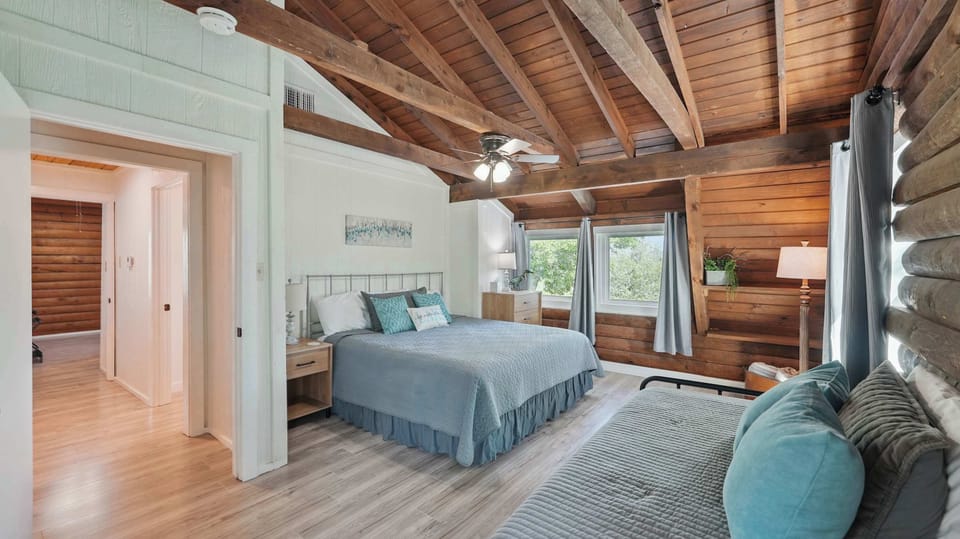 The full primary bedroom upstairs combines a queen bed, day bed, and trundle bed for a flexible and comfortable layout.