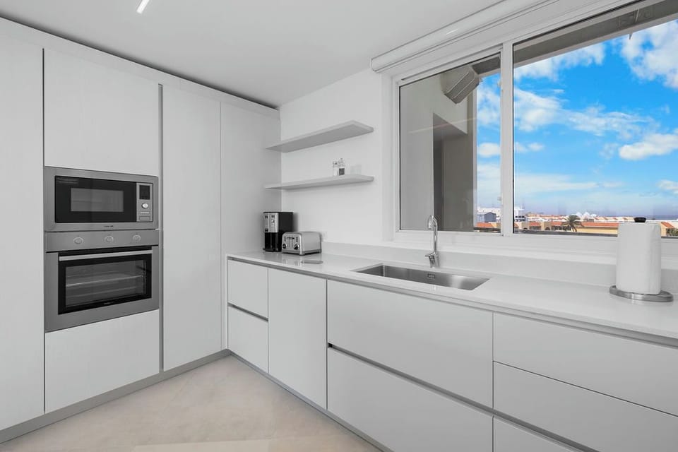 Your bright, modern kitchen is fully equipped with sleek appliances and opens to stunning rooftop views—perfect for preparing meals with a scenic backdrop.