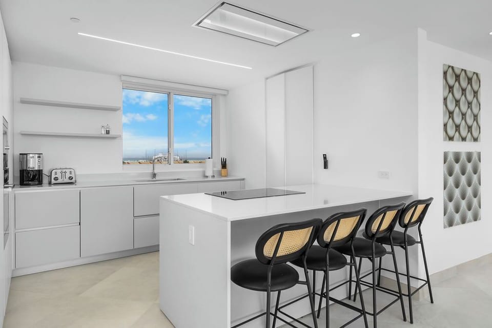 Picture yourself preparing meals in this sleek, modern kitchen with a spacious island, high-end appliances, and bright natural light flooding in through large windows.