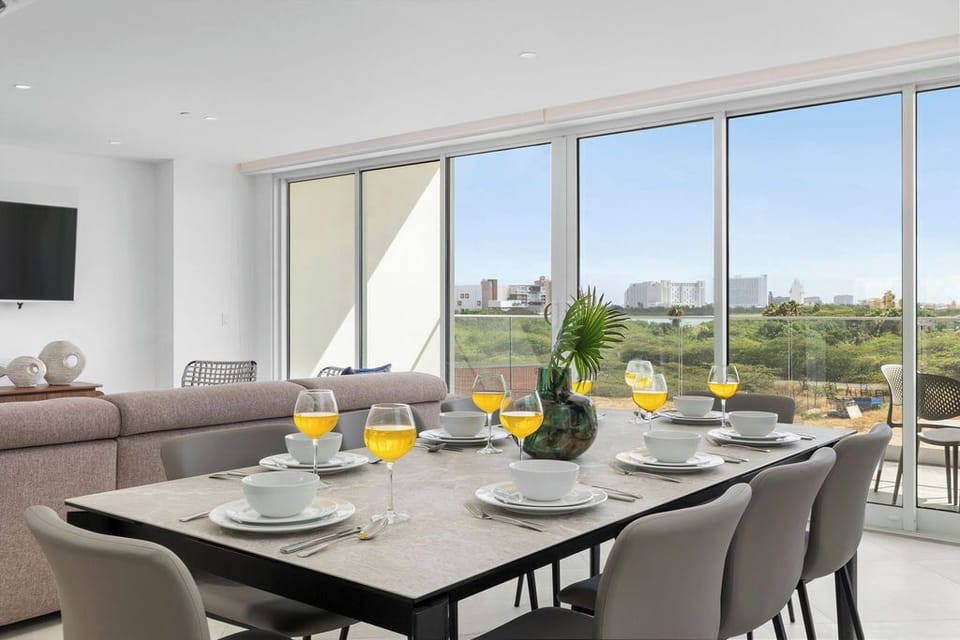 Gather around this sunlit dining table with stunning views of the surrounding greenery and cityscape. Picture yourself enjoying leisurely meals while natural light pours in through floor-to-ceiling windows.