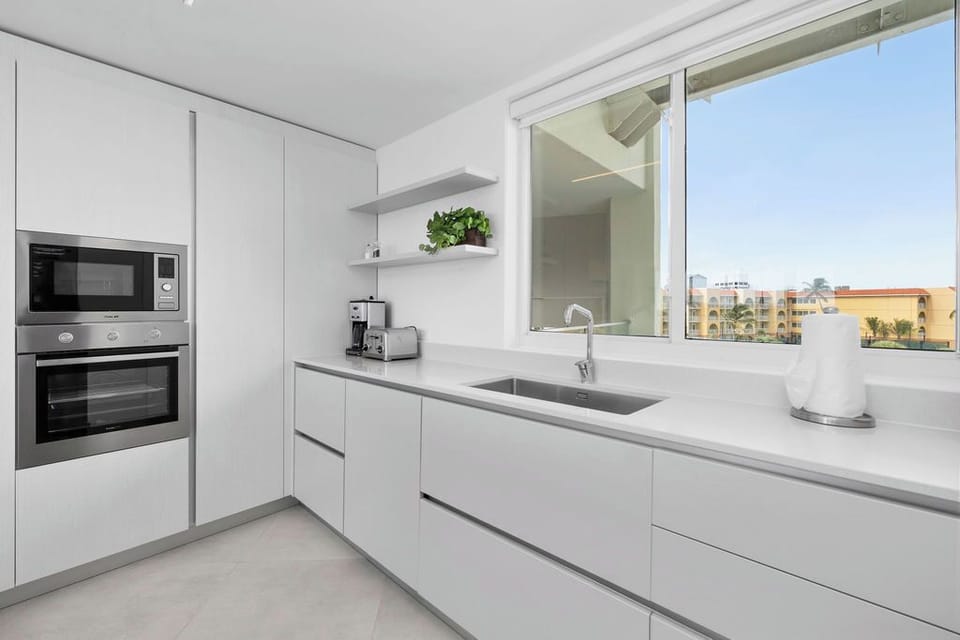 Your sleek, modern kitchen awaits with premium appliances and a sunny window view—perfect for brewing morning coffee before exploring the area.