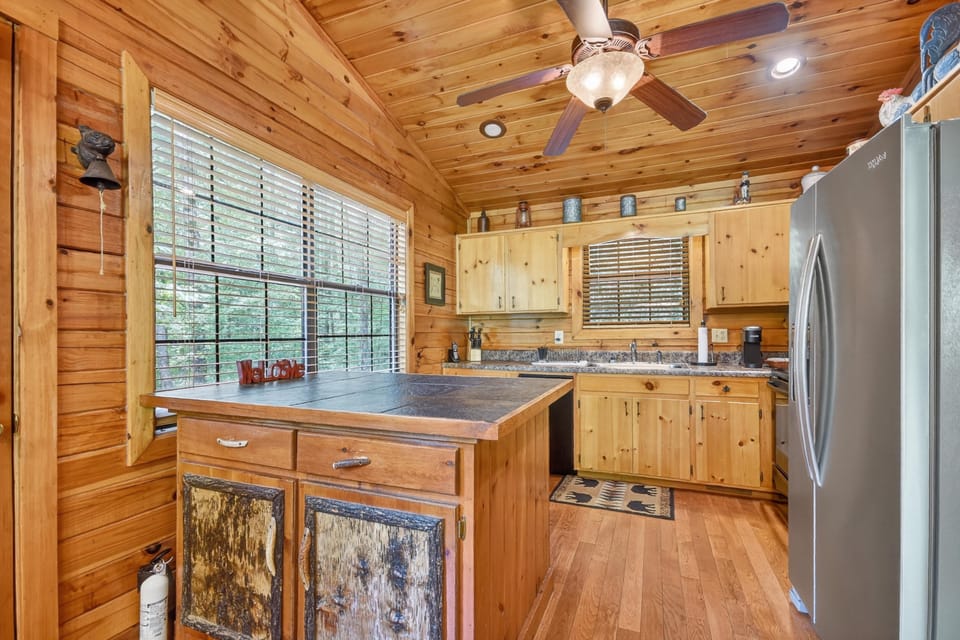 Rustic kitchen with wooden cabinetry and modern appliances, ideal for cooking.