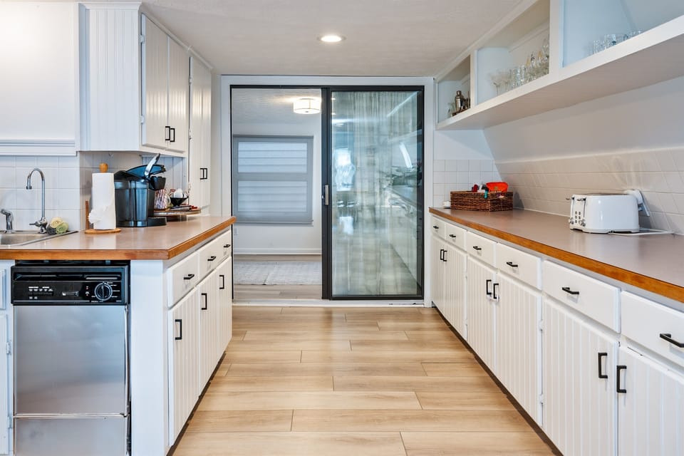 A well-equipped kitchen featuring a convenient coffee station and open-concept living area, offering a relaxing atmosphere with access to the outdoors. 🌿☕🌞