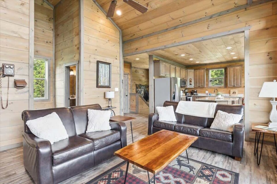 Living Room: Sleek leather couches invite relaxation beside a charming wooden coffee table!