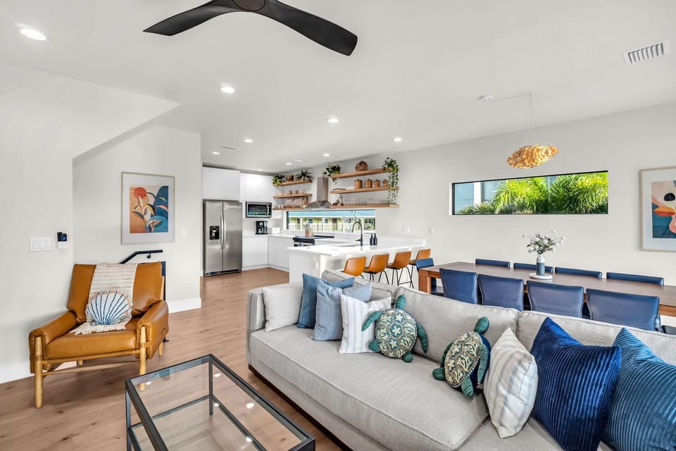 Airy open-plan living room w/ cozy seating & kitchen nearby