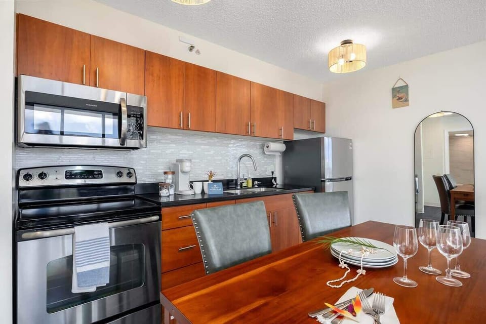 Beautifully appointed kitchen and dining area, featuring modern stainless steel appliances, warm wood cabinetry, and a charming dining setup perfect for entertaining or enjoying a home-cooked meal!
