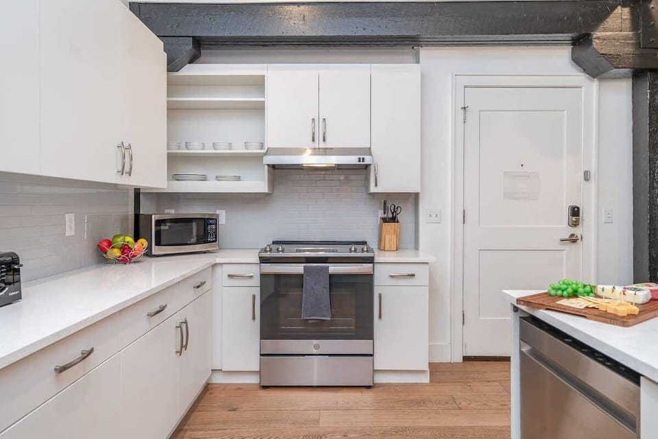 Fully equipped kitchen featuring stainless steel appliances, open counter space, and bar seating for 4 guests.