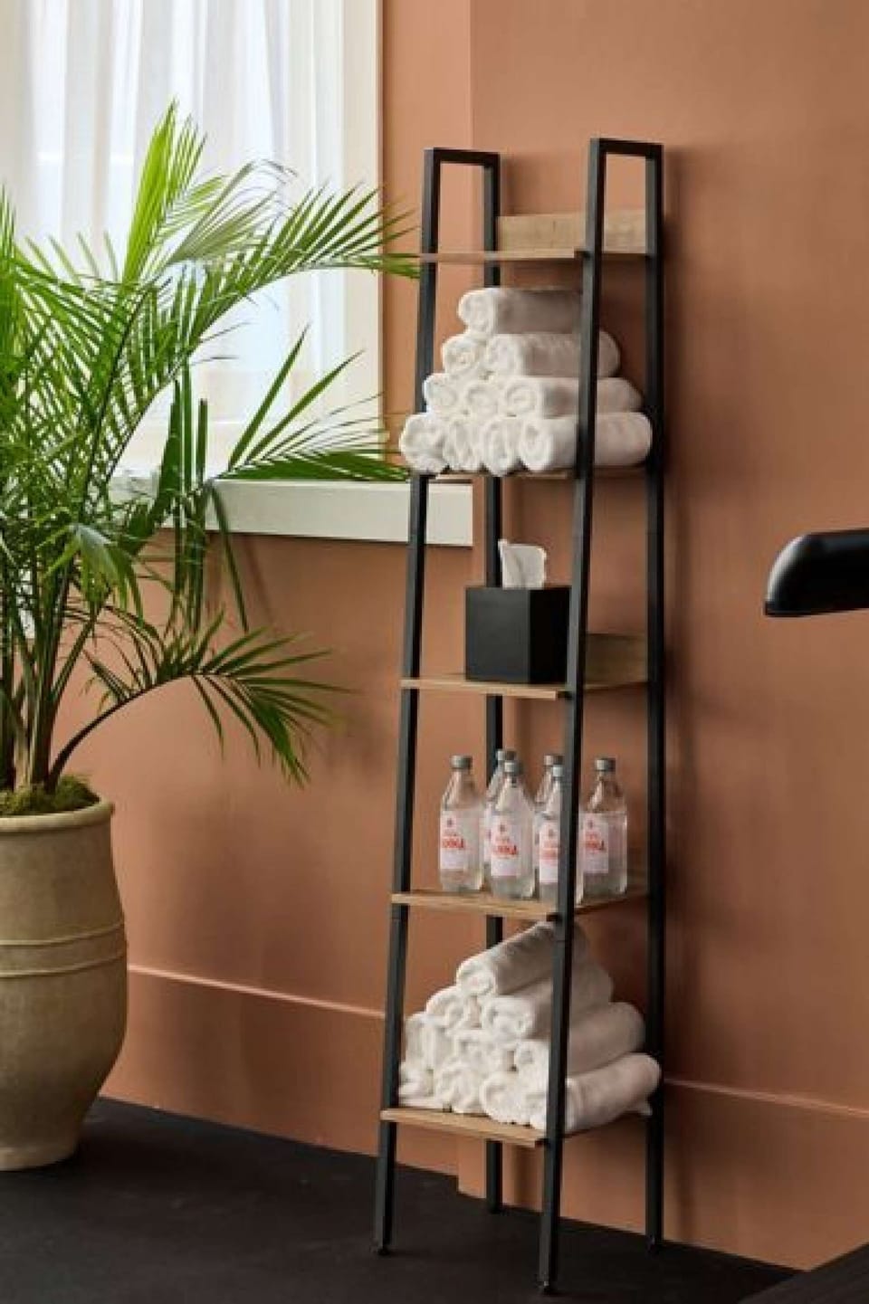 Shelf with towels, bottles, and tissue box