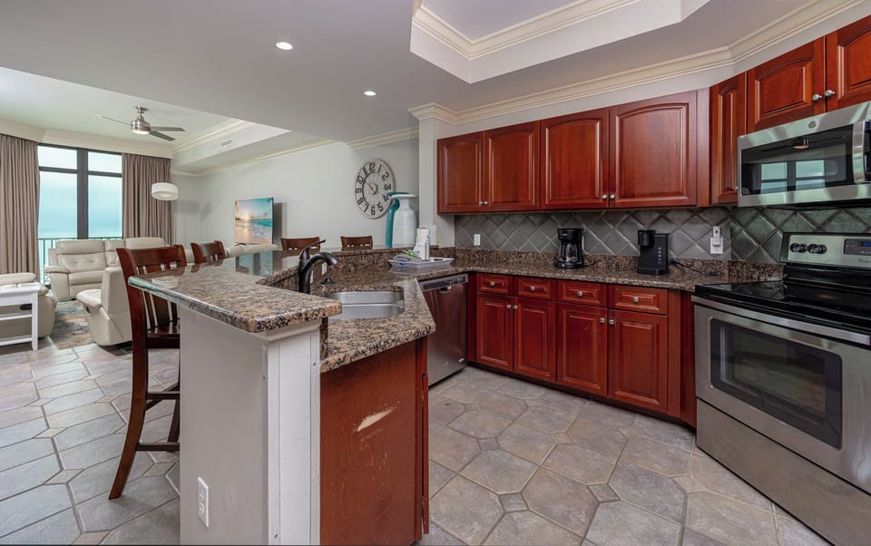 Prepare meals in this kitchen with elegant cabinetry, stainless appliances, and stylish backsplash