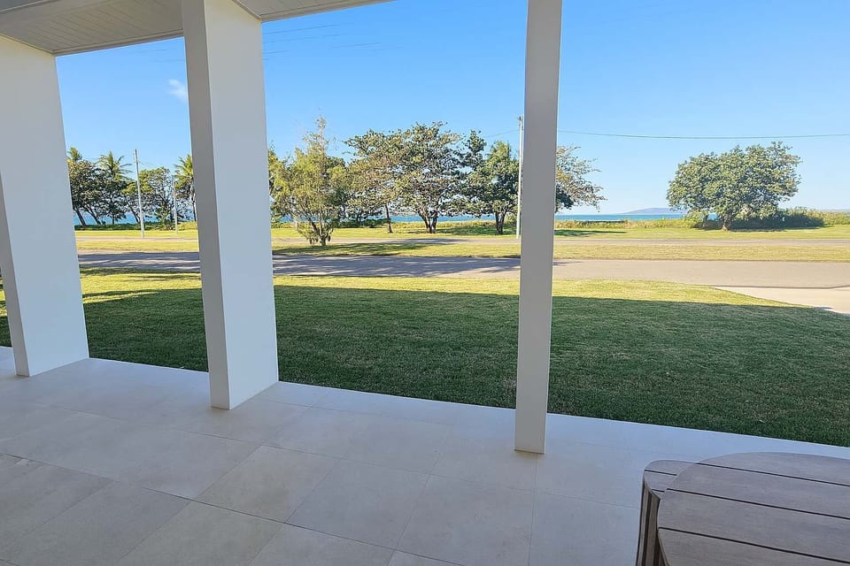 Covered outdoor area overlooking the lawn, perfect for morning coffee