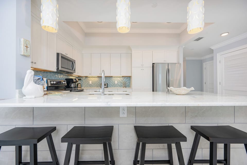 Stylish kitchen design with bar seating, stainless appliances, and elegant lighting for your culinary adventures