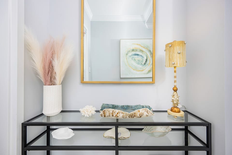 Admire the stylish entryway featuring decorative accents, a mirror, and a lamp to enhance your beachfront experience