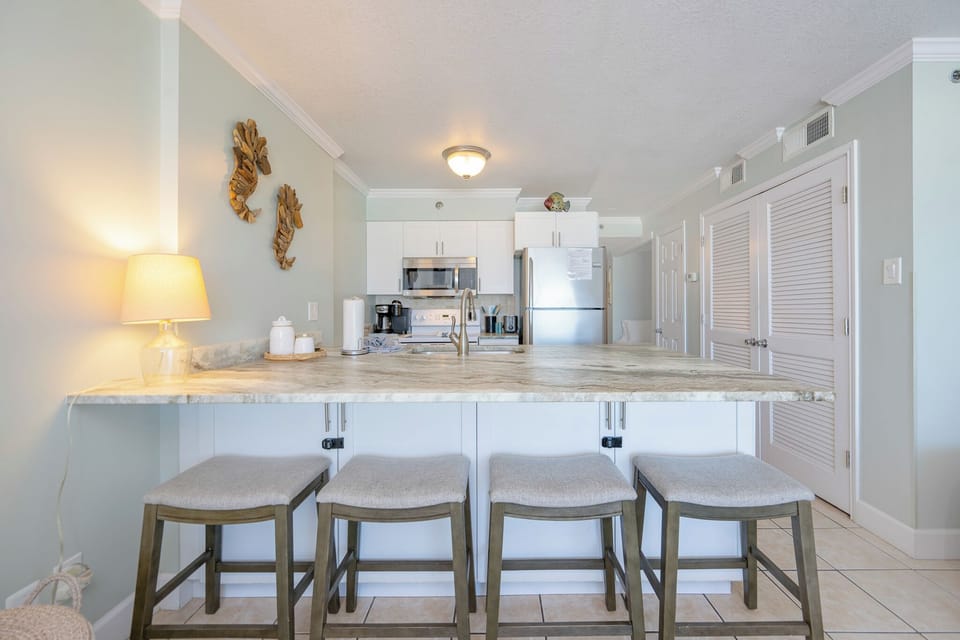 Kitchen features stainless appliances, elegant and spacious countertops, and stylish seating for a cozy dining experience