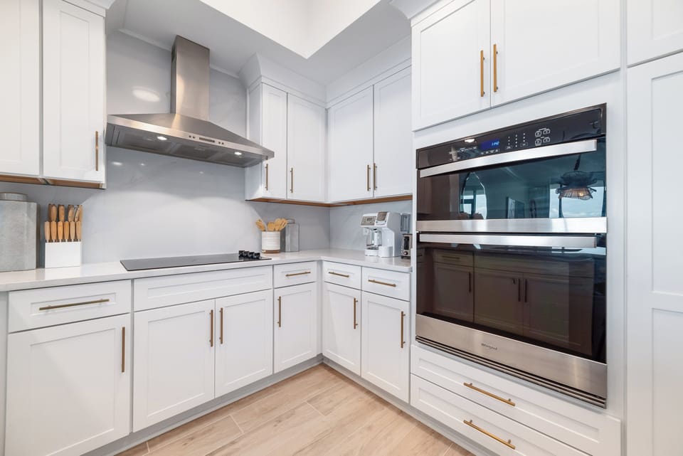 Enjoy cooking in this modern kitchen with upgraded appliances, coffee corner, and gold accents