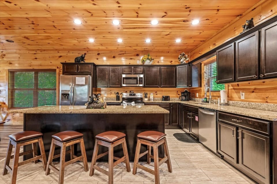 Whip up family favorites in this fully equipped kitchen featuring granite countertops, rich cabinetry, and stainless steel appliances—all surrounded by warm wood tones.