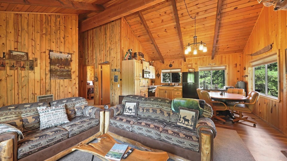 Cozy living room featuring rustic mountain décor, a smart TV, wood-burning stove, and plush, comfortable seating