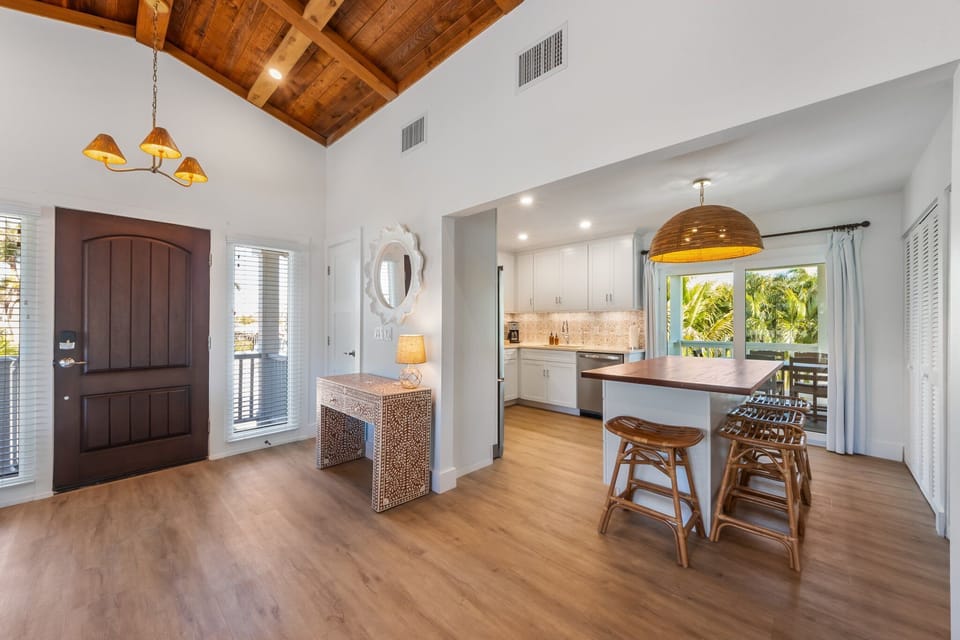 Fully stocked kitchen with stainless steel appliances and covered porch beyond.