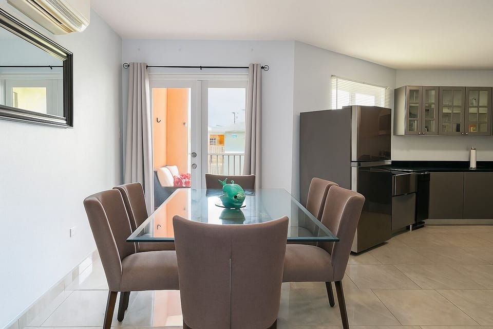 A A dining table for six people next to the kitchen and an exit to the balcony