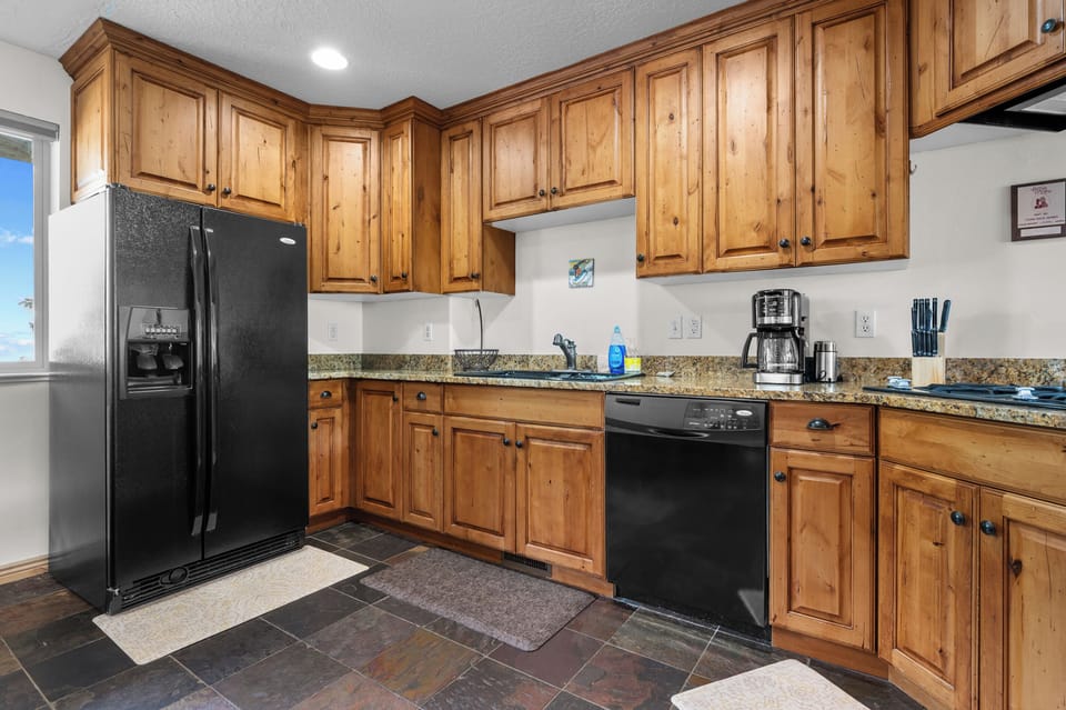 This spacious kitchen features generous counter space, a large fridge with icemaker, gas stove, and everything you need to cook like a pro.