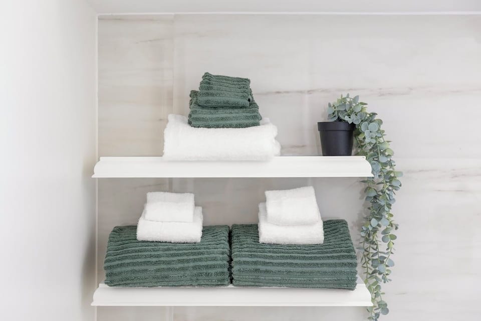 Fresh towels and neatly organized shelves for your stay.
