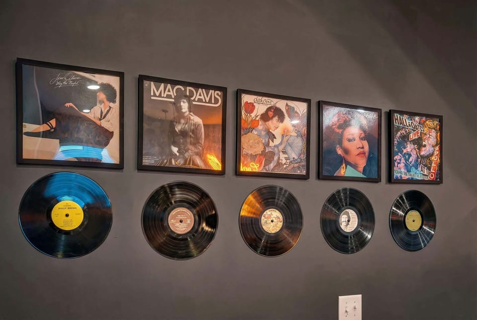 Framed records and albums decorate the dining room walls, a touch that says this house gets the vibe you came here to experience