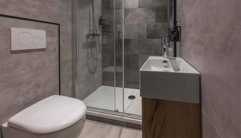 Rinse off comfortably in the bright shower and modern vanity.