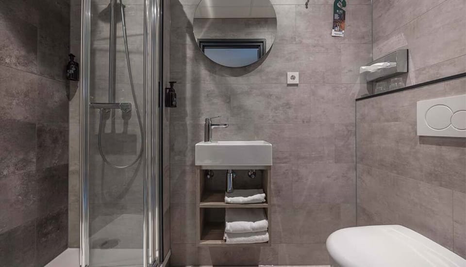 Refresh in a sleek, tiled bathroom with walk-in shower.