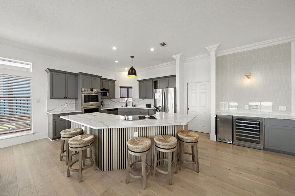 Spacious, sunlit kitchen with a marble island