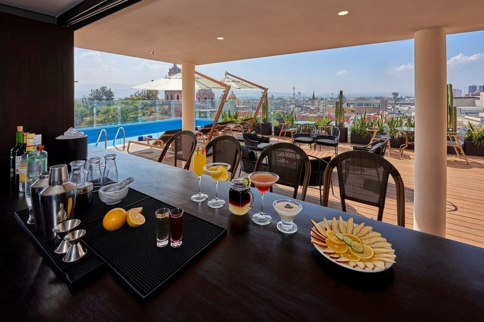 Sip crafted cocktails poolside while the city stretches below.