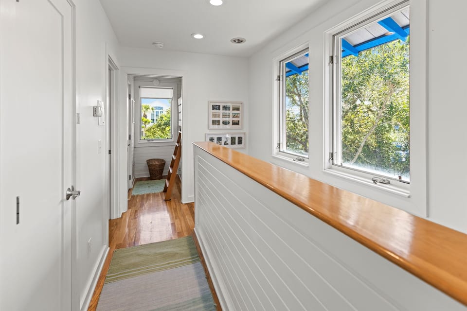 Bright hallway with natural light streaming through windows, showcasing beautiful tree views and thoughtful design details throughout your stay.