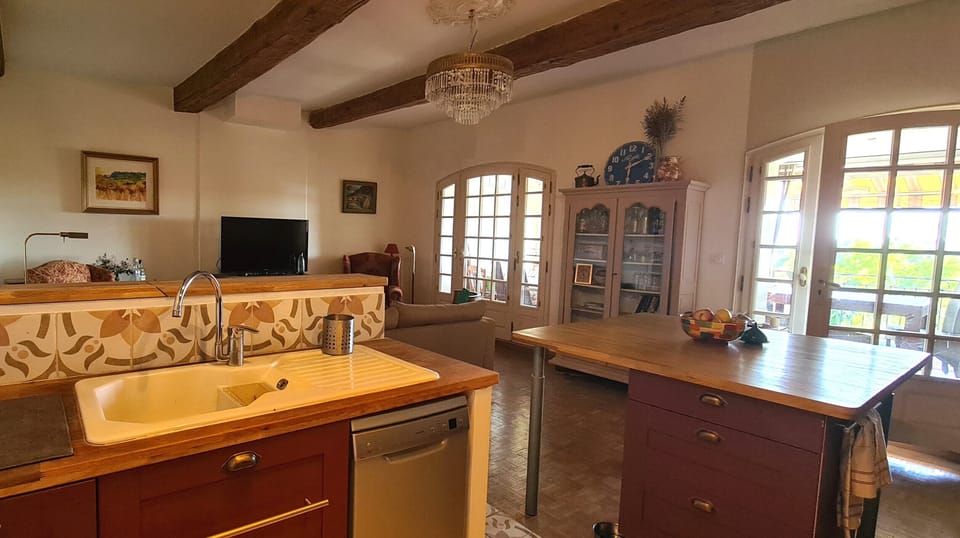 Kitchen with island bench leading to veranda