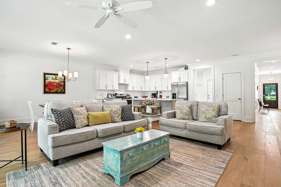 Open Living Room and Kitchen Flow - Sofa seating, kitchen island, and natural light connect the main gathering spaces.
