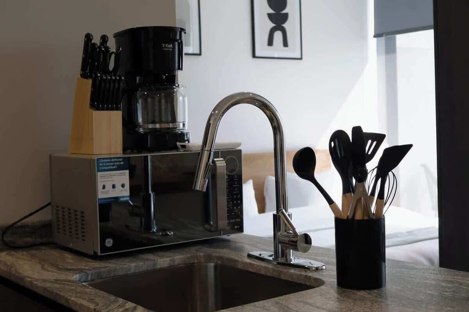 Kitchen sink area w/ modern faucet, coffee maker & cooking essentials