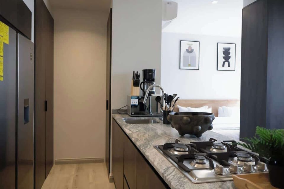 Sleek kitchen w/ cooktop, utensils & modern cabinetry