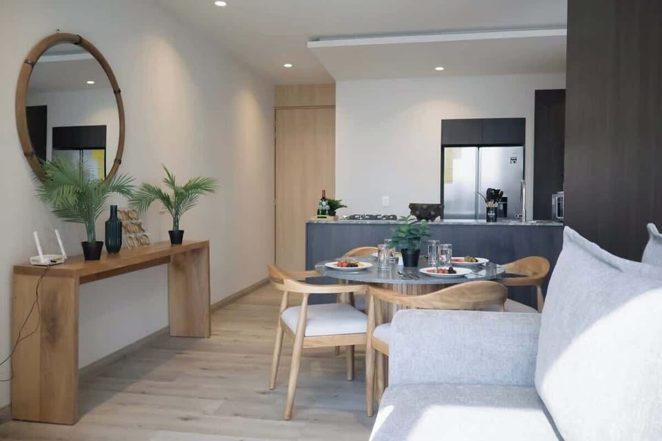 Bright open living & dining area w/ TV, sofa seating & warm wood accents