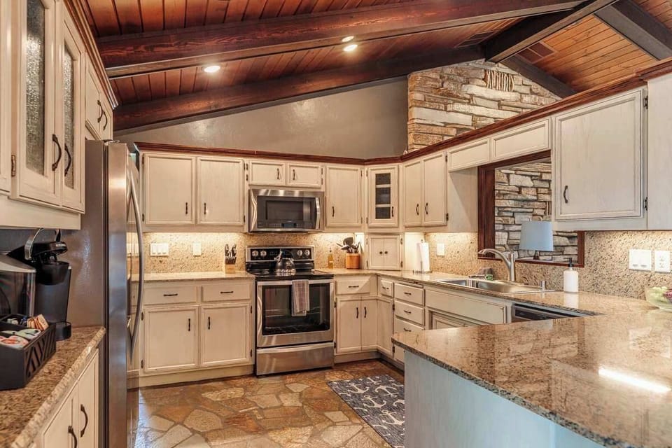 Bright kitchen with stainless steel appliances, spacious countertops, and a stylish coffee bar—fully equipped to make cooking and entertaining a breeze in this open-concept home.