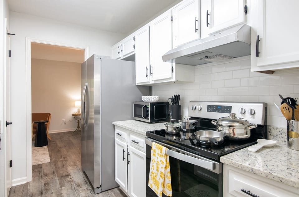 Well-equipped kitchen with stove, microwave, and clean white cabinetry—perfect for home-cooked meals.