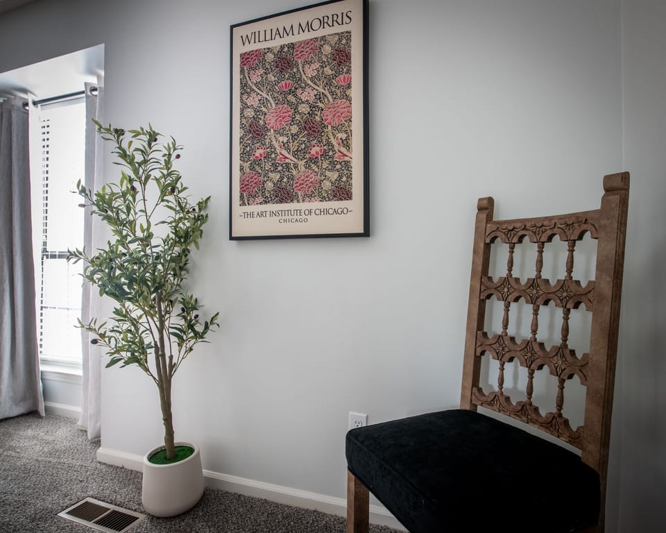 Wall décor and indoor plant add a peaceful, homely touch to the bedroom corner.