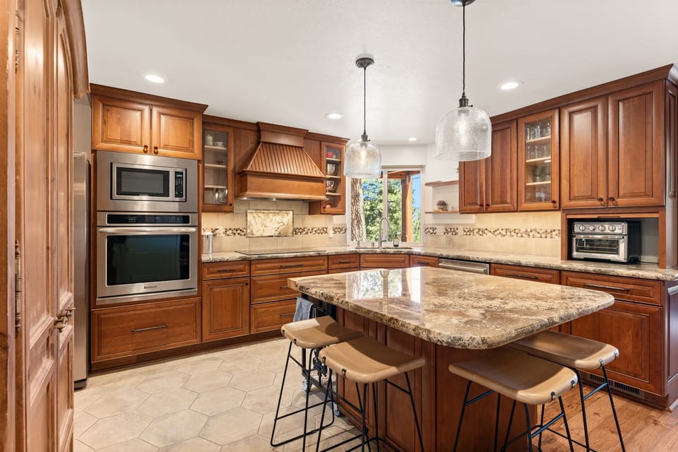 This cozy kitchen features sleek countertops, state-of-the-art appliances, and an island perfect for meal prep or casual dining, with seating for four. Whether you're cooking breakfast or pouring a glass of wine, it’s the heart of the Highland A-frame.
