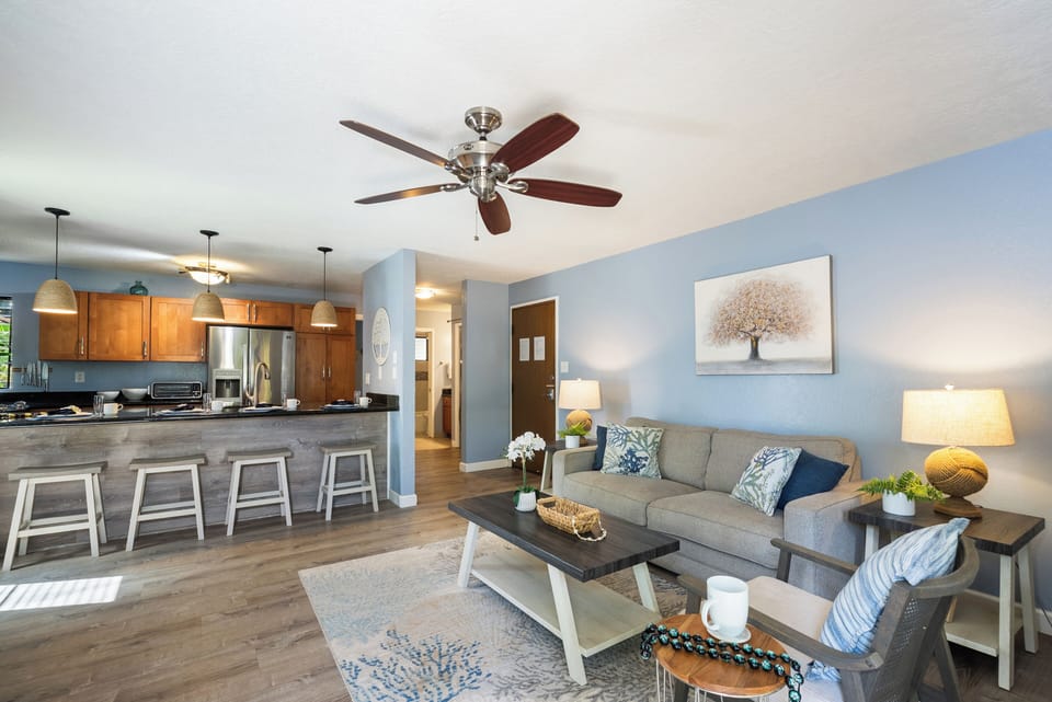 Living room with ceiling fan, natural light, and tropical charm.