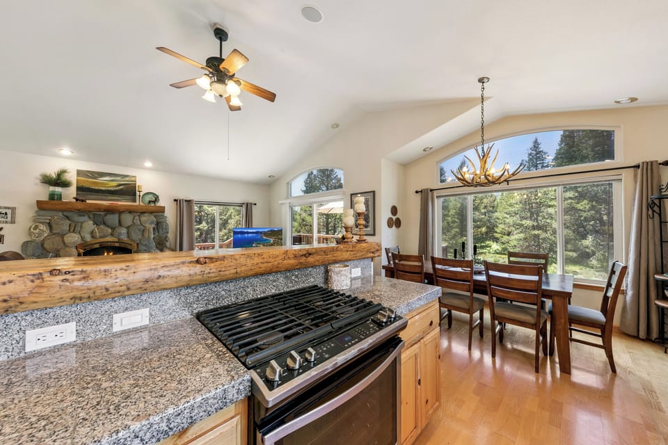Your spacious kitchen opens to dining with forest views—perfect for cooking together while enjoying nature's backdrop.