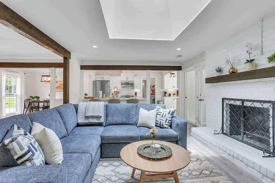 This living room is bright white and open concept, leaking into the kitchen and dining room area. With a non functional fireplace and an oversized skylight, this room provides ample natural lighting. 