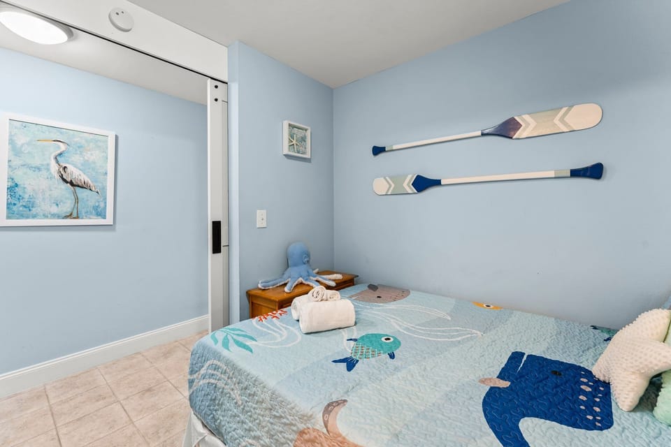 Cozy bedroom with ocean-themed decor and calming blue walls.