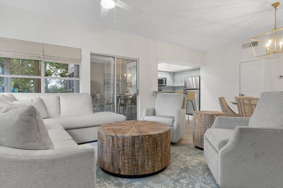 Comfort meets coastal style in this open-concept living area with plush seating and rustic wood accents.