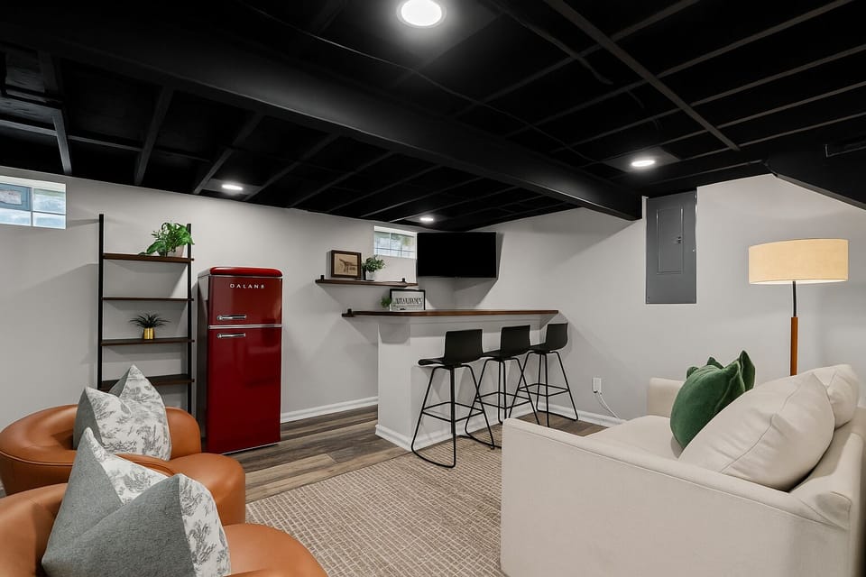 Fully equipped basement hangout with bar seating, Smart TV, retro fridge, and comfy lounge space—great for entertaining or relaxing.