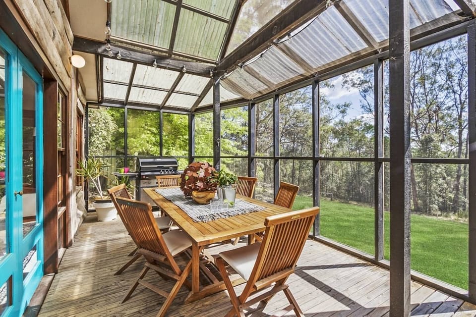 External dining area with BBQ protected by fly screens. 