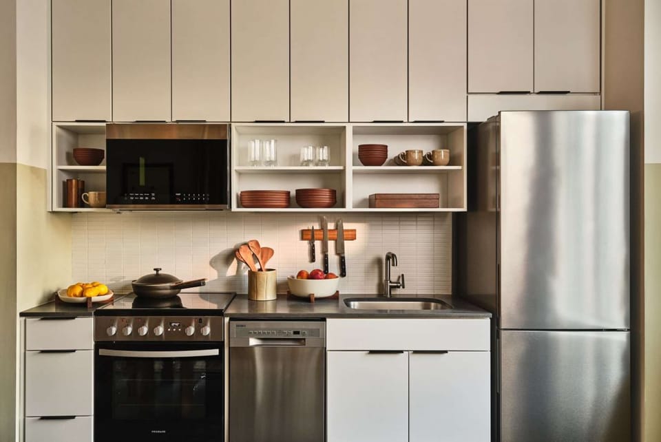 White cabinets with stove, sink, and plates on open shelves